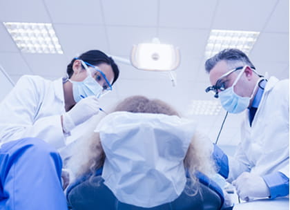 Two dentists treating patient